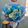 Bó hoa hồng và cúc nhuộm xanh dương gói giấy xanh